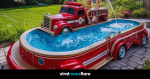 A vibrant red firetruck converted into a swimming pool, with a hose spraying water, set in a beautiful garden with a white house in the background.