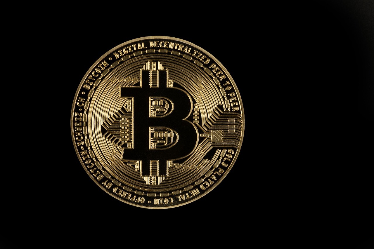Gold Bitcoin coin on a black background with intricate circuit-like patterns symbolizing cryptocurrency and blockchain technology.