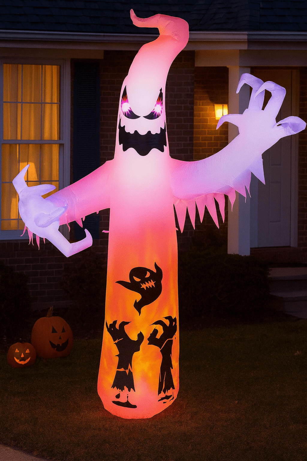 Large glowing ghost inflatable with eerie faces and silhouettes illuminated at night