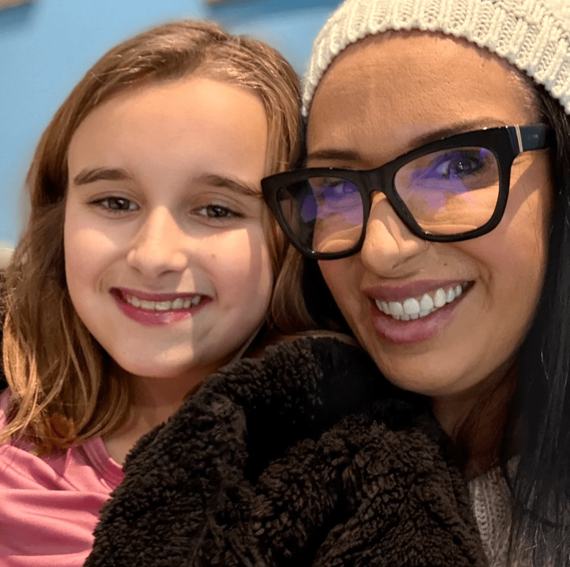 A smiling woman and her young daughter sharing a warm moment together, reflecting family, resilience and the values behind community-led fundraising