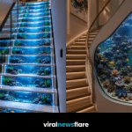 Spectacular aquarium staircase featuring a towering tropical fish tank surrounded by curved stairs in a luxury modern home.